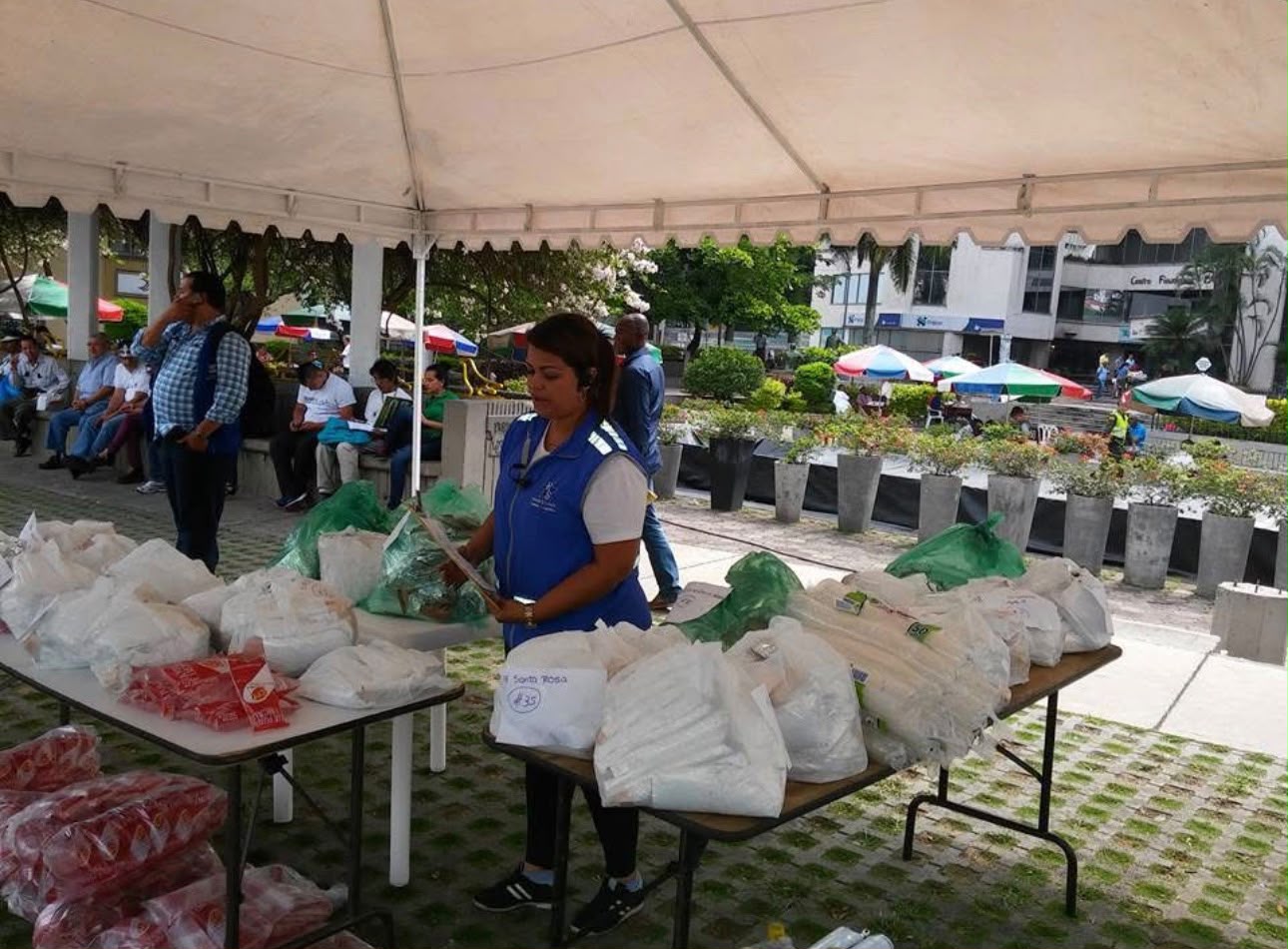 Una integrante organiza bolsas y materiales bajo una carpa
